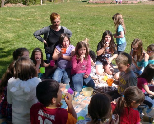 Schülerin und Schüler picknicken gemeinsam in der Nachmittagsbetreuung.
